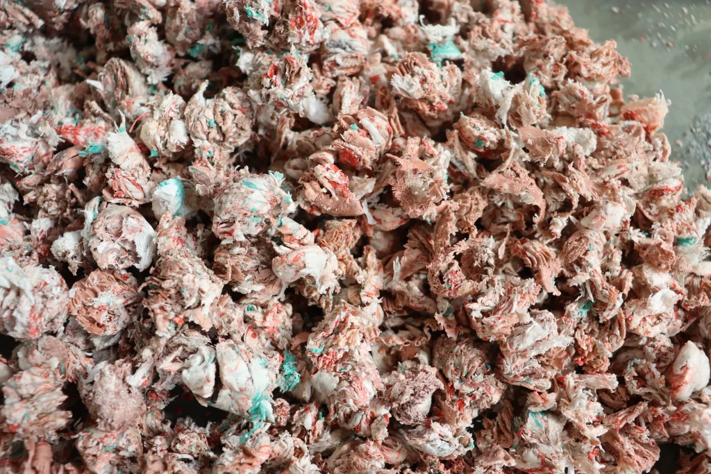 Pink plastic flakes before pelletizing